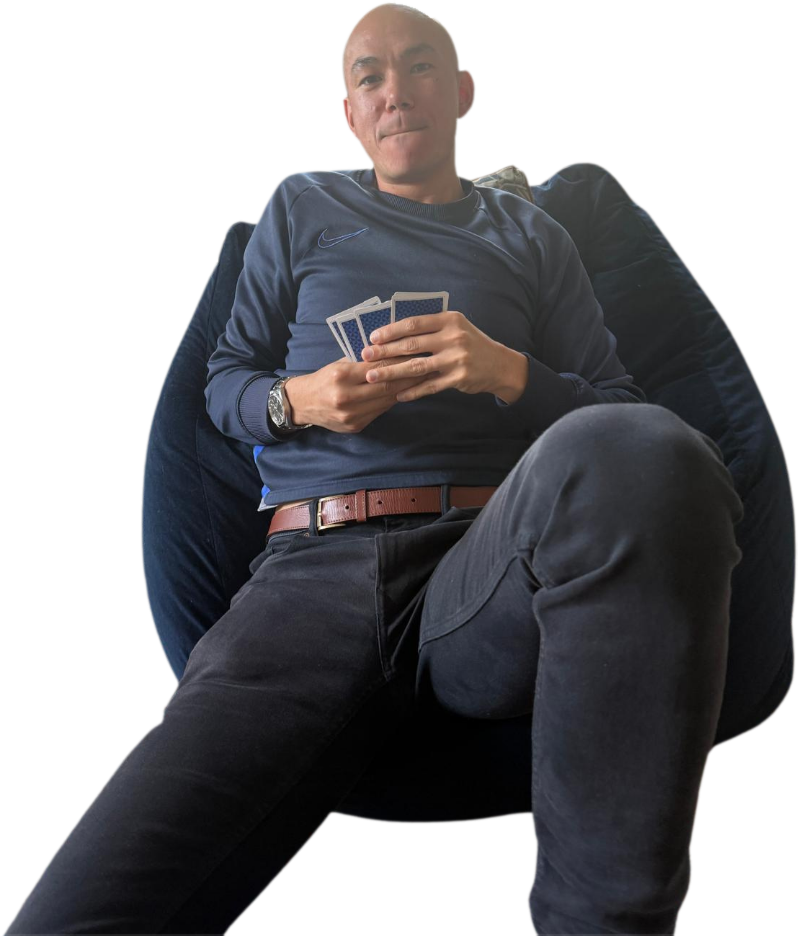 Harry Collins sunk into a beanbag holding a hand of cards